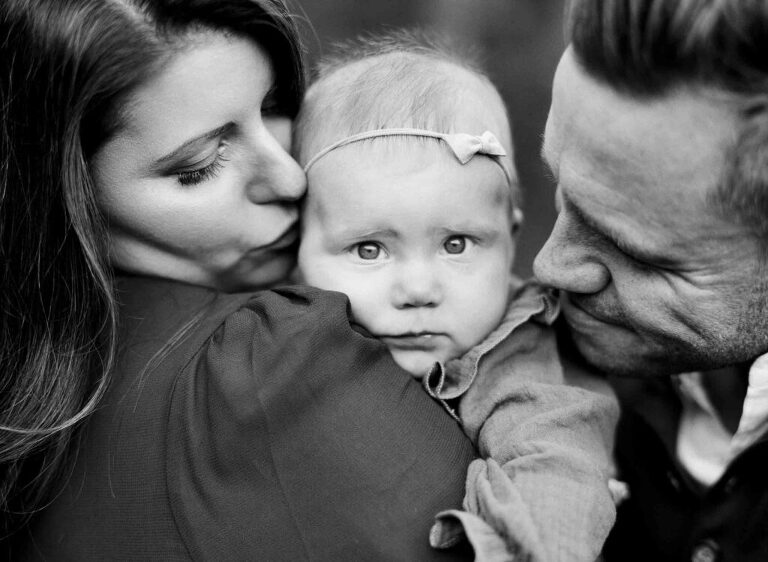 B&W solum baby held by mother and father, by Alex Friendly